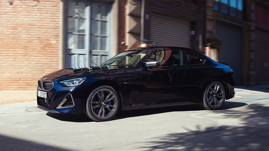 BMW M240i xDrive Coup&eacute; G42 2021 Black Sapphire metallic vue de profil devant entrep&ocirc;t de stockage